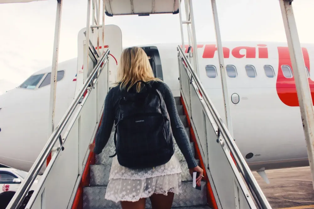 woman boarding plane wearing backpack